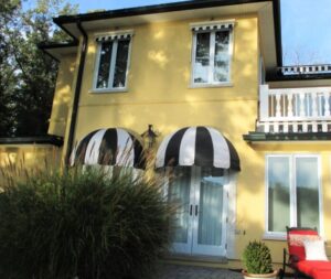 carroll architectural shade custom black and white dome awnings on a yellow building